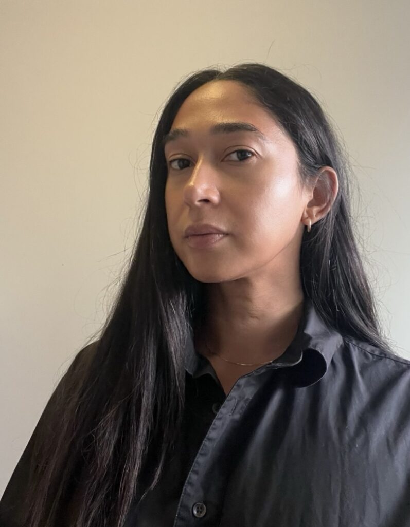 Portrait of Chanelle Adams. Black shirt, long dark straight hair and light brown skin.